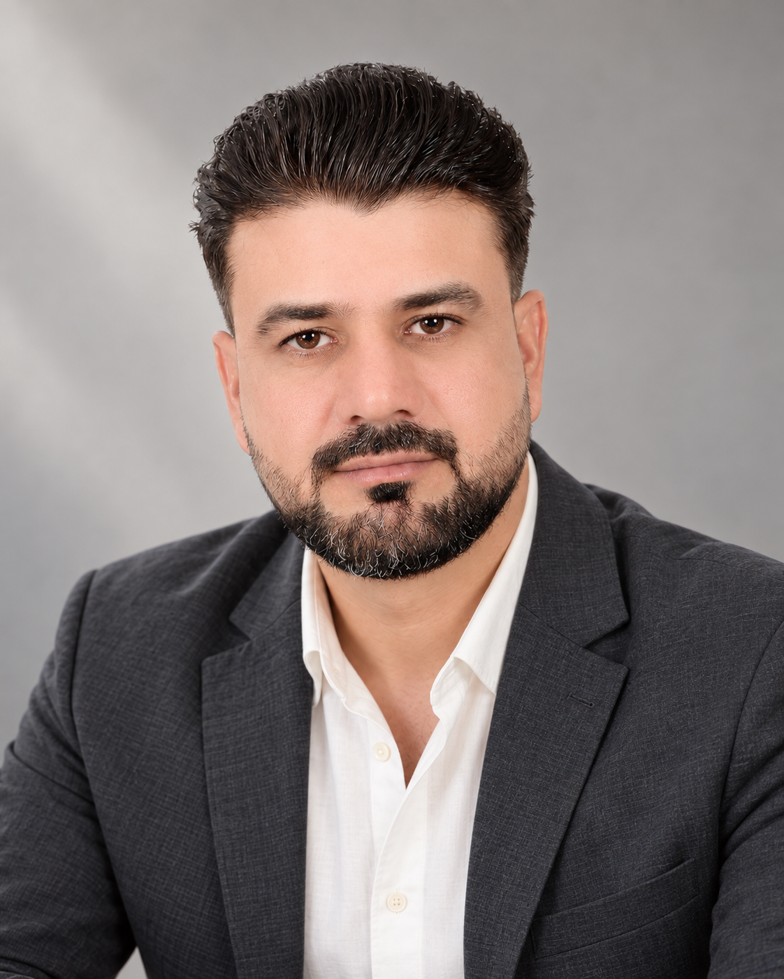 AI-assisted editorial portrait of Adil Shehzad in a charcoal blazer against a soft grey background